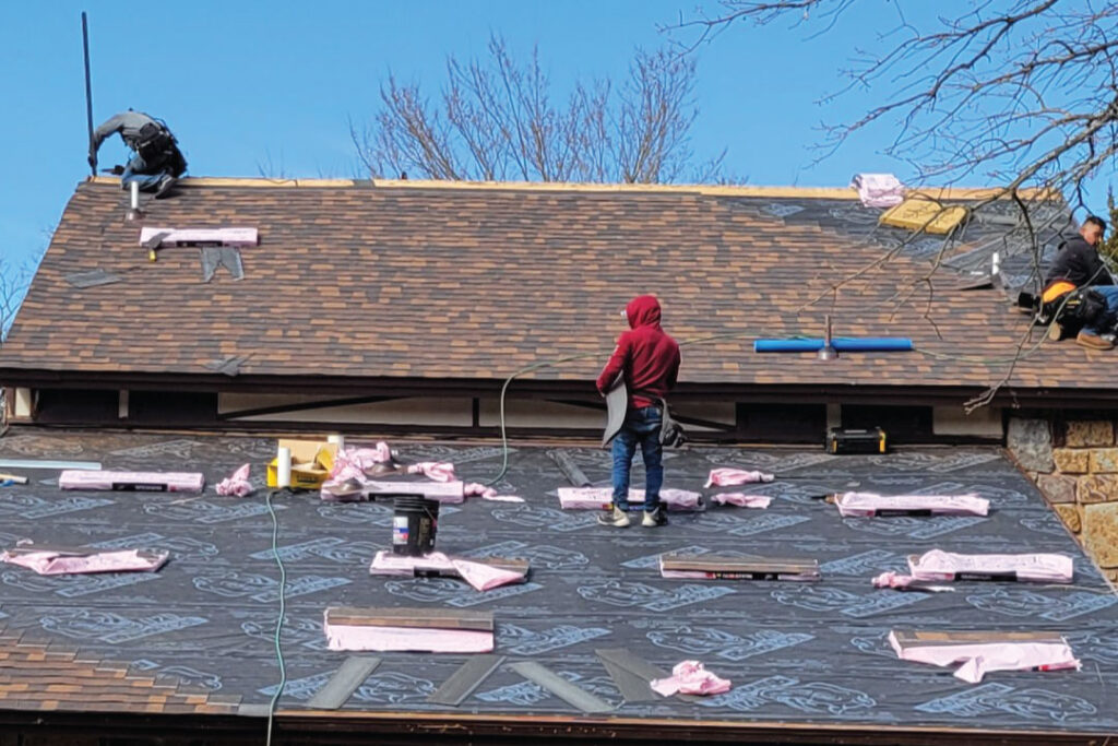team of expert roofing installers working to replace storm damaged roof in Oklahoma City